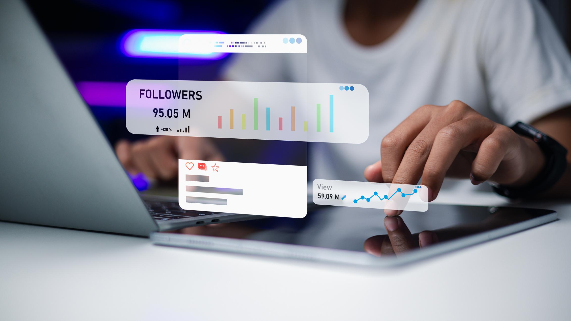 Content creator analyzing social media engagement and follower growth on laptop